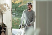 Hombre con bicicleta volviendo a casa a través de la puerta principal - foto de stock