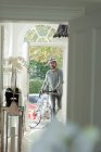 Man with bicycle returning home through front door — Stock Photo
