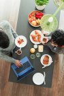 Paar genießt Frühstück und arbeitet am Laptop in der Morgenküche — Stockfoto