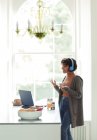 Mulher em fones de ouvido em videochamada trabalhando em casa no laptop — Fotografia de Stock