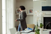 Mulher trabalhando em casa falando no telefone inteligente na janela — Fotografia de Stock