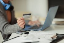 Nahaufnahme einer Frau, die mit Kreditkarte am Laptop Rechnungen online bezahlt — Stockfoto