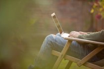 Uomo che utilizza il computer portatile in giardino — Foto stock