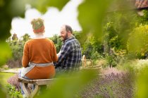 Счастливая пара отдыхает от садоводства на заднем дворе — стоковое фото