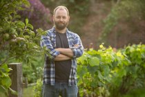 Портрет уверенный красивый мужчина с бородой в саду — стоковое фото