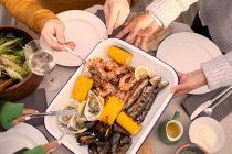 Вид сверху на друзей, наслаждающихся свежим морепродуктом — стоковое фото