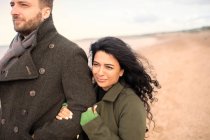 Щаслива пара в зимових пальто на пляжі — стокове фото