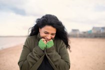 Щаслива жінка в зимовому пальто на пляжі — стокове фото
