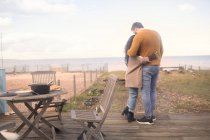 Affettuosa coppia che si abbraccia sul patio della spiaggia dell'oceano — Foto stock