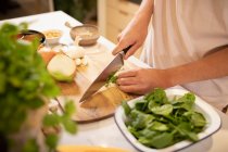 Mann kocht in Küche und schneidet Gemüse — Stockfoto
