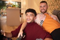 Glücklich gay männlich pärchen watching fernsehen auf sofa — Stockfoto