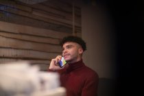 Молодой человек разговаривает по смартфону в офисе — стоковое фото