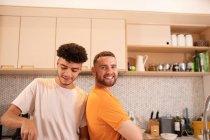Retrato feliz gay macho pareja en cocina - foto de stock