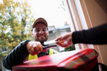 Homem pagando homem de entrega para entrega de alimentos com cartão inteligente na porta da frente — Fotografia de Stock