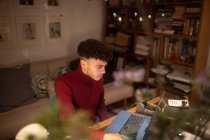 Jovem trabalhando em casa no laptop no escritório em casa — Fotografia de Stock