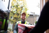 Entrega amigável homem entregando comida na porta da frente — Fotografia de Stock