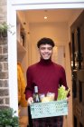 Портрет щасливий молодий чоловік отримує доставку продуктів біля входу — стокове фото
