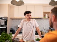 Gay male couple talking in kitchen — Stock Photo