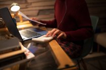 Junger Mann mit Taschenrechner bezahlt Rechnungen am Laptop im Home Office — Stockfoto
