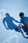Junger beinamputierter Sprinter bereit auf sonniger blauer Sportstrecke — Stockfoto