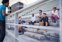 Amici atleti che parlano in tribuna dello stadio — Foto stock