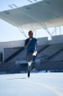Молодий спортсмен-ампутатор біжить на сонячно-блакитній спортивній трасі — стокове фото