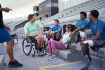 Різноманітні молоді спортсмени розмовляють на стадіоні відбілювачі — стокове фото