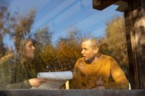 Geschäftsleute diskutieren am sonnigen Café-Fenster über Papierkram — Stockfoto