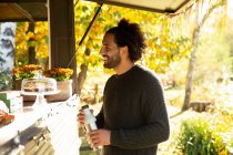 Smiling male customer ordering from food truck in autumn park — Stock Photo
