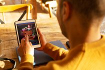 Чоловік з цифровим планшетом замовляє їжу додатком на цифровому планшеті — стокове фото