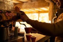 Maschio barista preparare cappuccino alla macchina da caffè espresso in caffè — Foto stock