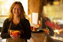 Portrait heureuse propriétaire de café féminin avec cappuccino — Photo de stock