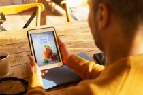 Proprietário do restaurante masculino olhando para o site de entrega em tablet digital — Fotografia de Stock