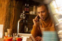 Владелец мужского кафе принимает заказ по телефону на цифровой планшет — стоковое фото