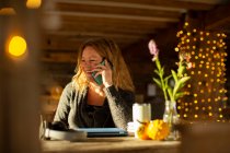 Glückliche Geschäftsfrau, die im Café mit dem Smartphone spricht — Stockfoto