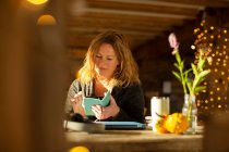 Businesswoman using smart phone at cafe table — Stock Photo