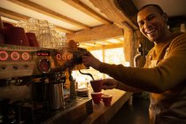 Portrait happy male barista preparing coffee at cafe espresso machine — Stock Photo