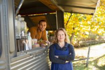 Portrait confident food cart owners in autumn park — Stock Photo