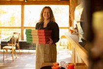 Retrato feliz mujer pizzería propietario sosteniendo cajas de pizza - foto de stock