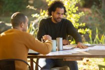 Empresários discutindo papelada à mesa no parque — Fotografia de Stock