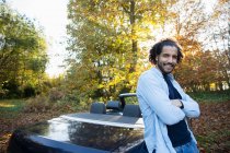 Portrait happy man at convertible in autumn park — Stock Photo