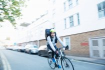 Männlicher Fahrradkurier liefert Essen auf städtischer Straße aus — Stockfoto