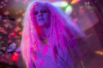 Portrait femme confiante avec les cheveux roses dans la boîte de nuit — Photo de stock