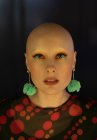 Close up portrait fashionable woman with shaved head and earrings — Stock Photo