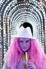 Portrait fashionable woman with pink hair in fedora under arch lights — Stock Photo
