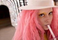 Nahaufnahme Porträt stilvolle Frau mit rosa Haaren, die aus Stroh trinkt — Stockfoto