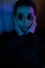 Portrait cool stylish young man wearing sunglasses in dark — Stock Photo