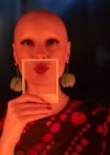 Portrait beautiful stylish woman with shaved head holding polaroid — Stock Photo