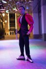 Porträt exzentrischer stylischer junger Mann bei Nacht unter Neonlicht in der Stadt — Stockfoto