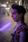 Эксцентричный молодой человек на городском тротуаре ночью — стоковое фото